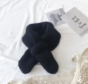 Detail of black ribbed knit baby scarf with crossover pull-through design for warmth