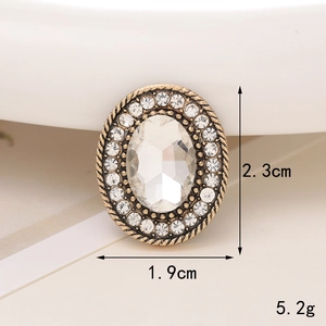 Macro detail of vintage gold oval charm with rhinestones showing 1.9cm x 2.3cm dimensions