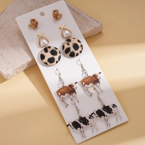 Detail of ten-piece earring set featuring cow print patterns and faux pearl accents