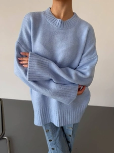 Detail of light blue oversized knit sweater showing soft texture and crew neck design