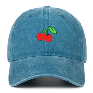 Close-up of red cherry embroidery on washed blue cotton twill baseball cap with stitching detail