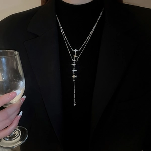 Close-up of double-layer stainless steel star necklace worn by a model in formal attire