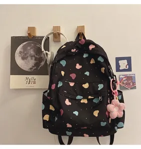 Close-up of cute cartoon bear prints on a black backpack with a pink flower plush charm