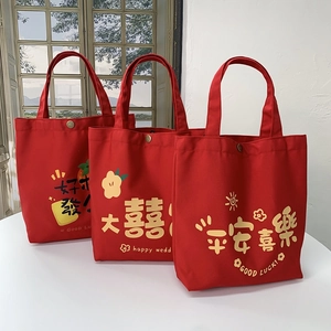 Detail of red wedding canvas tote bags with snap buttons and festive Chinese prints
