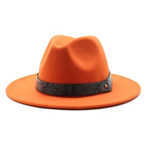 Detail of orange fedora hat featuring a snakeskin pattern band and gold metal rivet