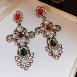 Nahaufnahme von Vintage-Barock-Ohrringen mit roten Strasssteinen und Perlen