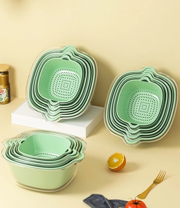 Nesting stack of mint green and clear plastic draining baskets for compact kitchen storage