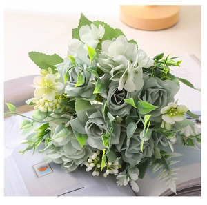Primer plano de un ramo de rosas y hortensias artificiales gris-verde en una revista