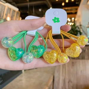 Detail of colorful resin heart beads on high-elastic hair bands in green and yellow