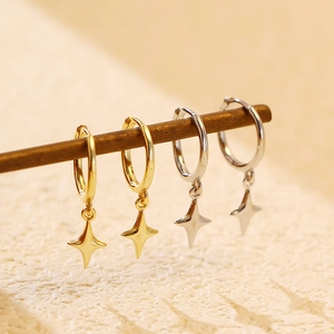 Macro view of gold and silver S925 sterling silver four-pointed star hoop earrings