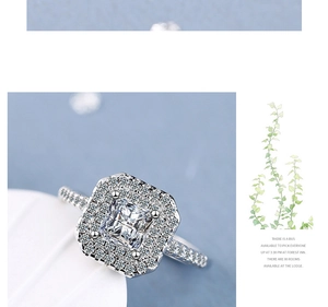 Macro detail of silver ring with large square zircon and pavé setting on blue background