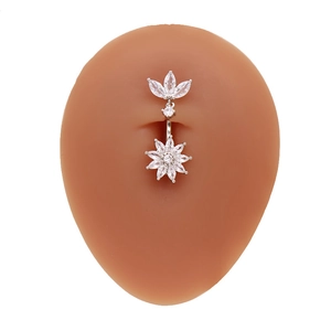 Vue macro d'un piercing nombril avec zircon cœur et pendentif fleur sur modèle