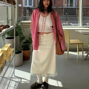Jupe midi en satin avec dentelle et chemise à carreaux dans un décor de café cosy
