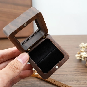 Detail of walnut wood ring box with black velvet lining and clear window view