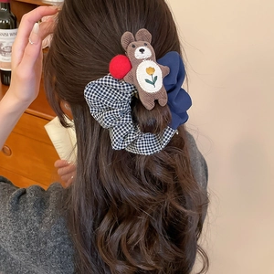 Detailed back view of a grid pattern bow scrunchie with a cute brown bear charm