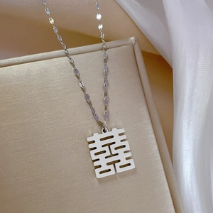 Macro view of a silver titanium steel necklace featuring a traditional Xi character pendant