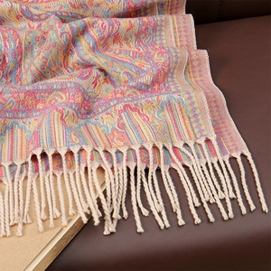 Close-up of colorful paisley scarf with detailed knit texture and beige fringe accents
