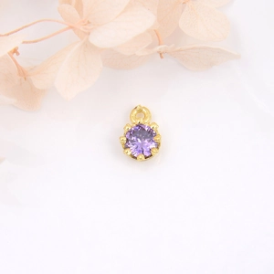Macro shot of 18k gold plated crown pendant with purple zircon for DIY jewelry making