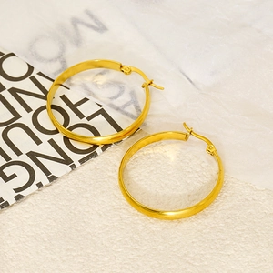 Polished 18k gold-plated stainless steel hoop earrings on a textured stone display