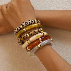 Detail of stacked acrylic resin bangles with leopard print and marble texture on wrist
