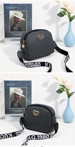 Close-up of heart logo hardware and wide logo strap on vintage dark grey crossbody bag