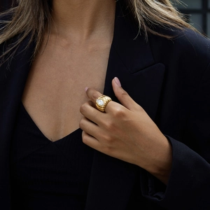 Détail d'une bague en acier doré 18K avec gemme marquise portée par un mannequin