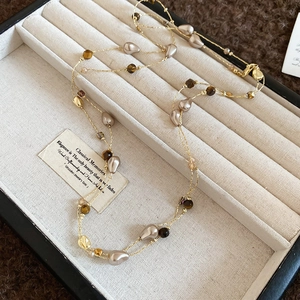 18k gold plated necklace with tiger eye stone and pearls on a cream jewelry tray