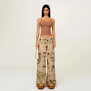 Slim fit brown ribbed camisole paired with desert camo cargo pants and white handbag