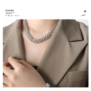 Detail view of a triple-layered silver chunky chain necklace in sleek industrial style