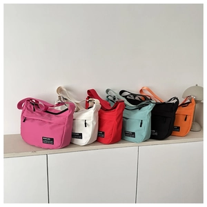 Row of colorful nylon tote bags in pink, white, red, green, black and orange