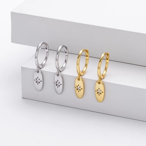 Detailed close-up of S925 silver and gold earrings with engraved octagonal star pendants