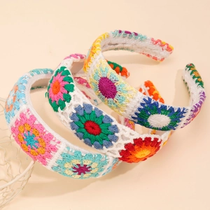 Detail shot of three handmade crochet flower headbands with colorful knitted patterns