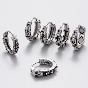 Detail of vintage silver punk earrings with skull and cross motifs in cast stainless steel