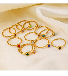 Golden stainless steel rings with colorful birthstones on smooth cream silk fabric