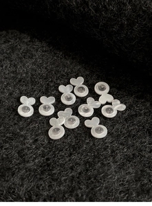 Macro shot of heart-shaped silicone earring backs on black felt background