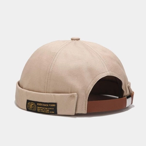 Detail view of khaki cotton docker hat showing adjustable leather strap and metal buckle