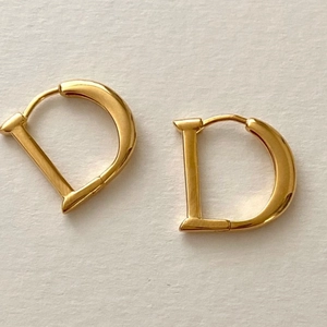 Polished gold D-shaped sterling silver huggie hoop earrings for women in a minimalist style