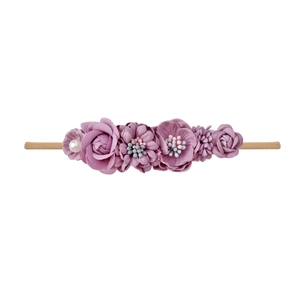 Detail of purple floral baby headband with soft fabric roses, pearls and elastic nylon strap