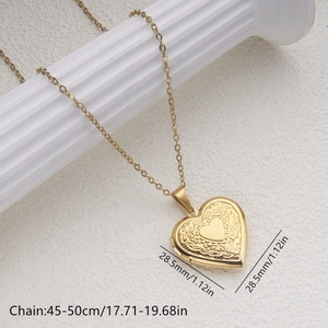 Detail showing the 28.5mm gold heart locket pendant with floral engraving on a white stand
