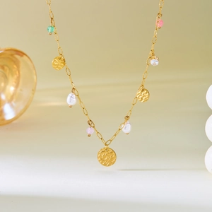 Détail du collier chaîne dorée avec perles blanches, perles colorées et pendentifs martelés