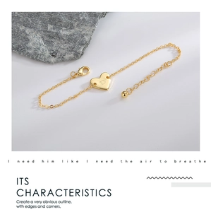 Détail d'un bracelet cœur doré avec lettre D gravée et sa chaîne de réglage ajustable