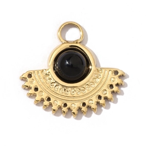 Macro shot of a gold sunburst pendant with black stone and fine filigree details