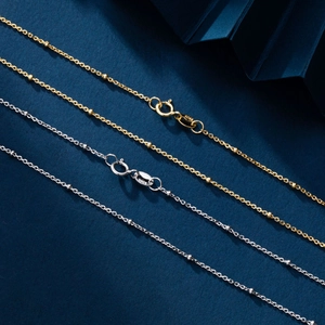 Detailed macro view of S925 sterling silver ball chains in gold and silver finishes