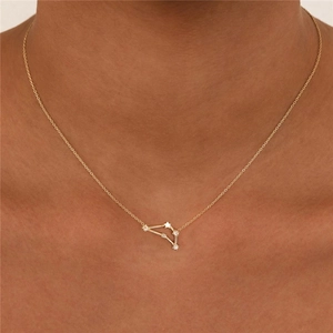 Close-up of golden zodiac pendant with white zircons on a delicate necklace chain