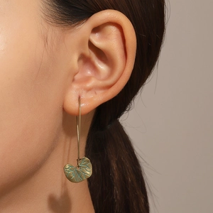Vue détaillée de boucles d'oreilles feuilles en bronze vintage sur un mannequin