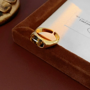 Macro detail of vintage gold-plated ring with rectangular tiger eye gemstone inlay