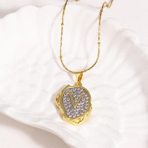 Close-up of a two-tone 18k gold plated necklace with a zircon-encrusted letter V pendant