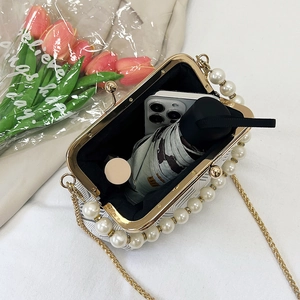 White pearl shell bag with gold chain strap, showing spacious interior for essentials