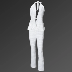 Detail of white halter neck jumpsuit showing textured bubble fabric and backless design