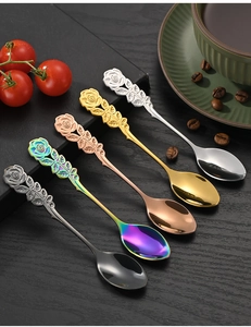 Close-up of assorted stainless steel rose-shaped handle spoons in diverse metallic finishes